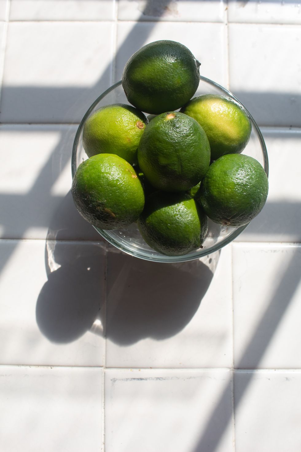 limes in a glass bowl in the sun