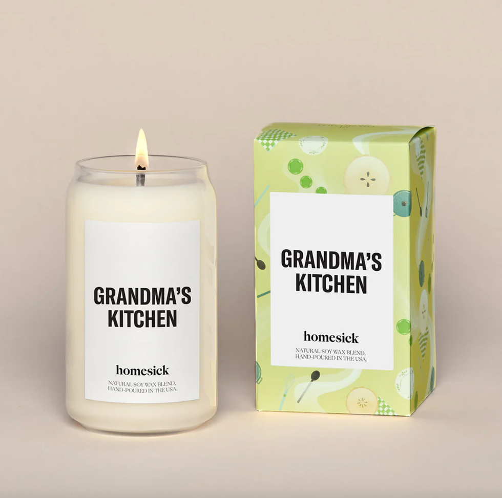 Lit "Grandma's Kitchen" candle next to its green decorative box.