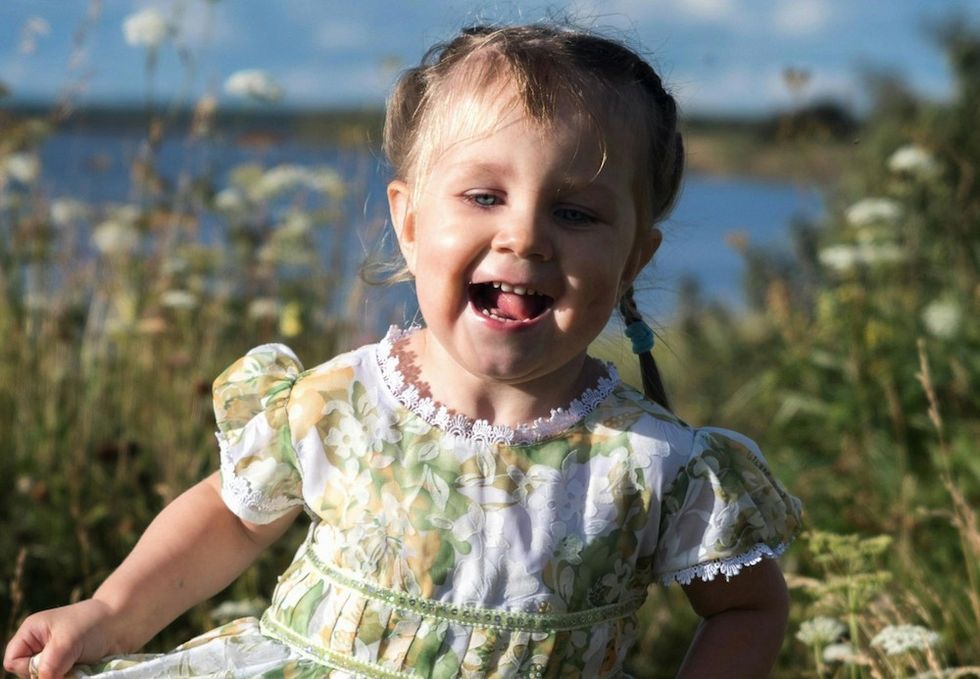 little girl running through a field