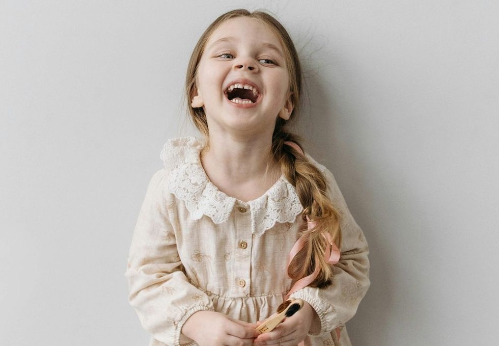little girl with a long braid laughing