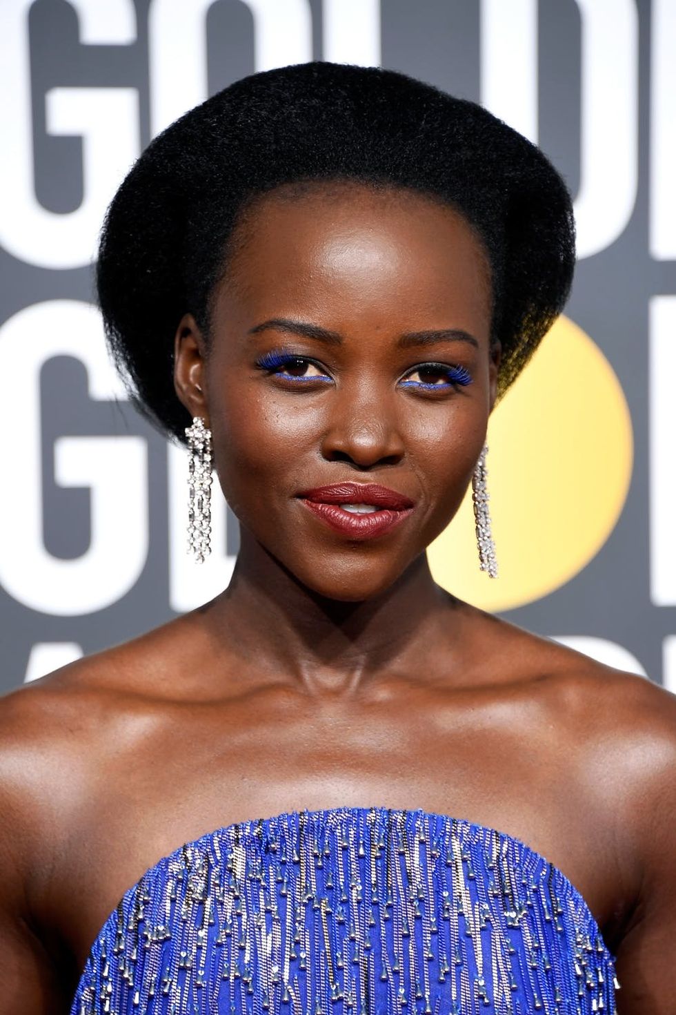 Lupita Nyong'o rocking blue eye makeup on the Golden Globes red carpet.