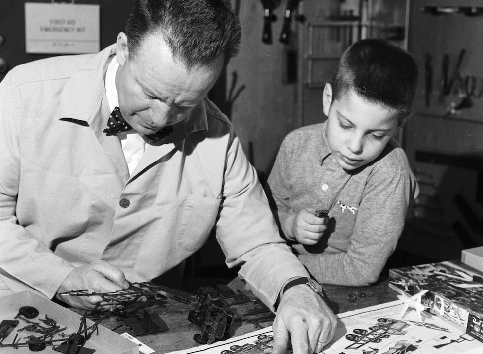 man and boy building model rocket