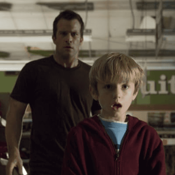 Man and boy in a store look surprised, illuminated by overhead lights.