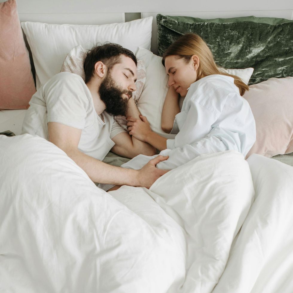 man and woman cuddling in bed