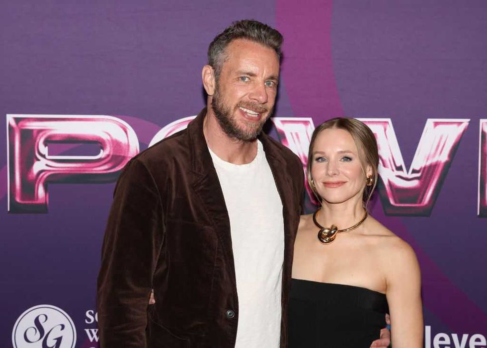 Man and woman posing together at a purple-themed event.