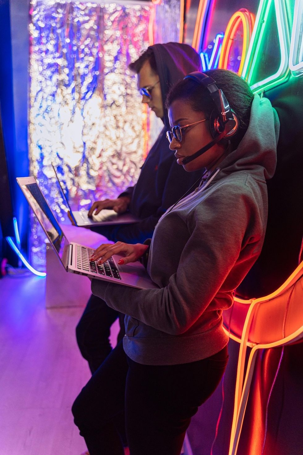 man and woman standing with their laptops