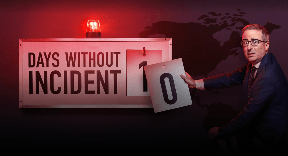 Man changing sign from 1 to 0 days without incident, red light flashing.