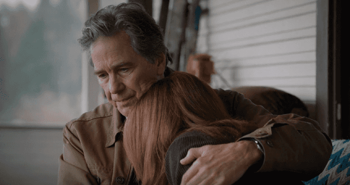 Man comforting a woman resting on his shoulder.