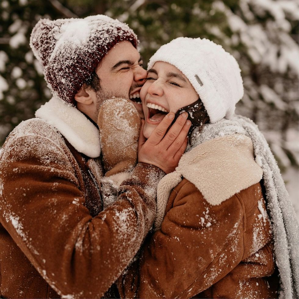 man kissing woman on the cheek in the snow
