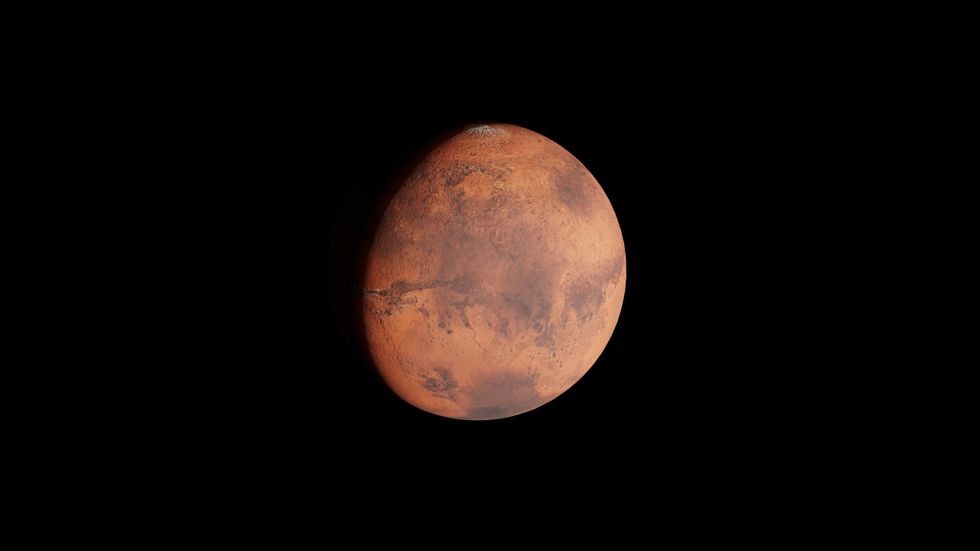 Mars against a black background, displaying rusty red and brown hues.