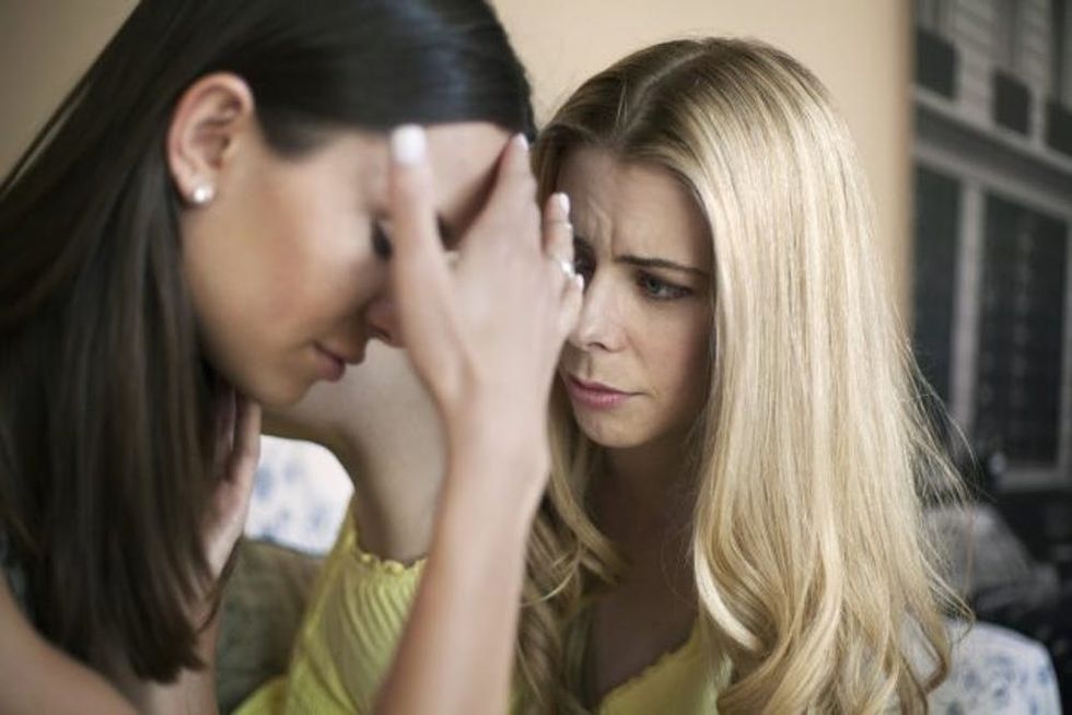 Mid adult woman consoling friend