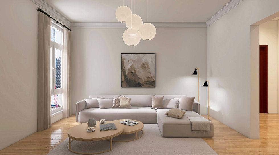 Minimalist living room with sofa, abstract art, round tables, and pendant lights.