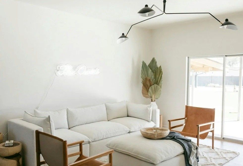 Minimalist living room with white sofa, modern lamp, and large window.