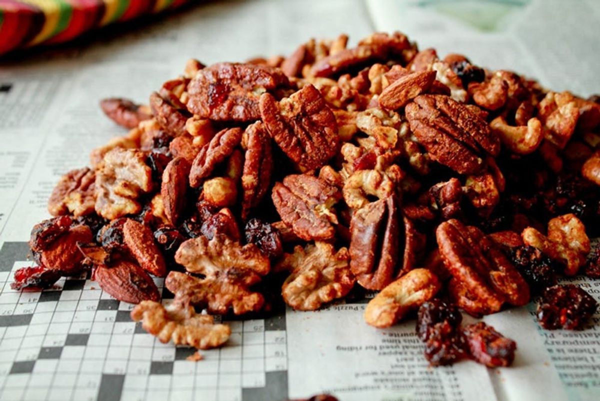 Mixed nuts and dried fruits on newspaper with crossword.