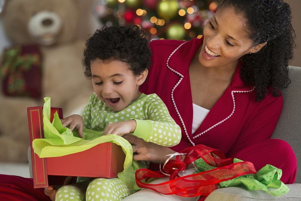 Mixed race mother and daughter opening Christmas present