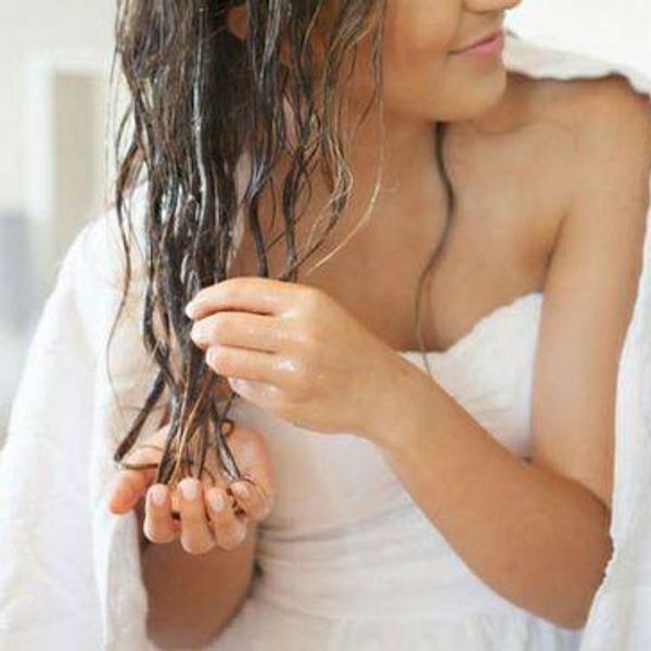 model puts a coconut oil and honey mask on the ends of her hair