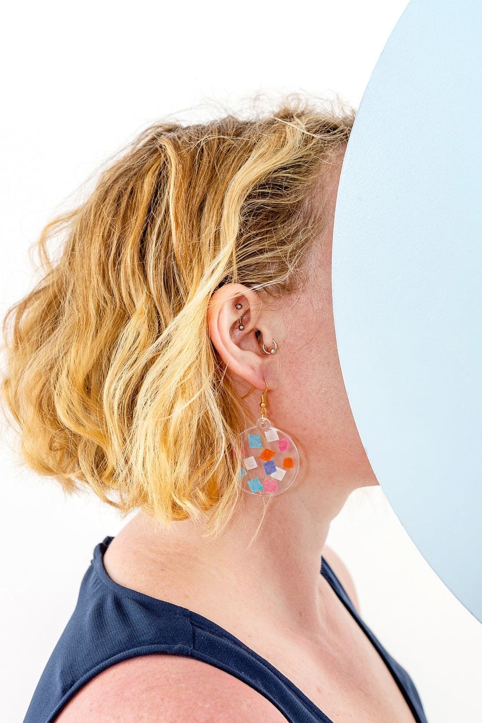 model wears circular rainbow confetti diy earrings