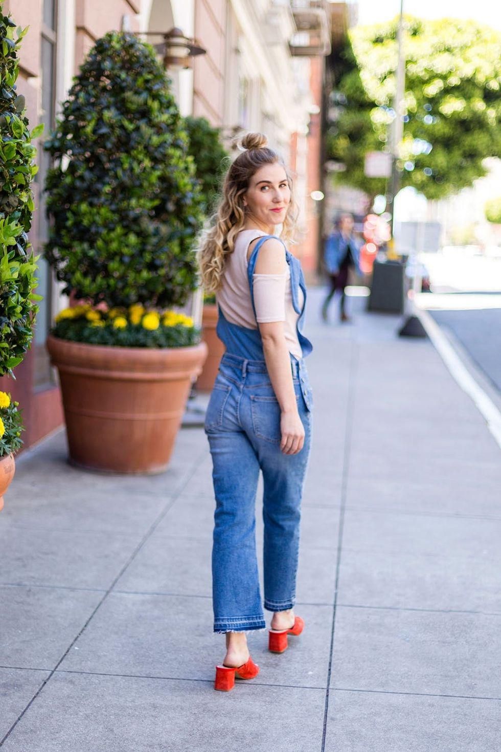 model wears overalls with red heels and pink top outside