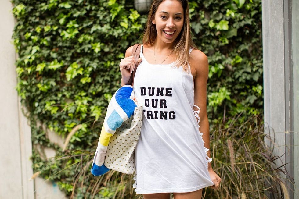 model wears the white Beach_Cover_Up with black letters outside