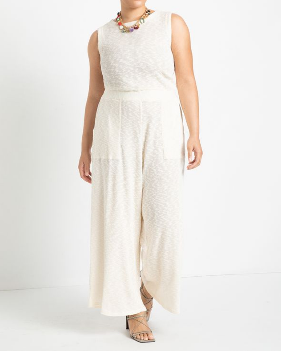 model wears white jumpsuit with strappy sandals