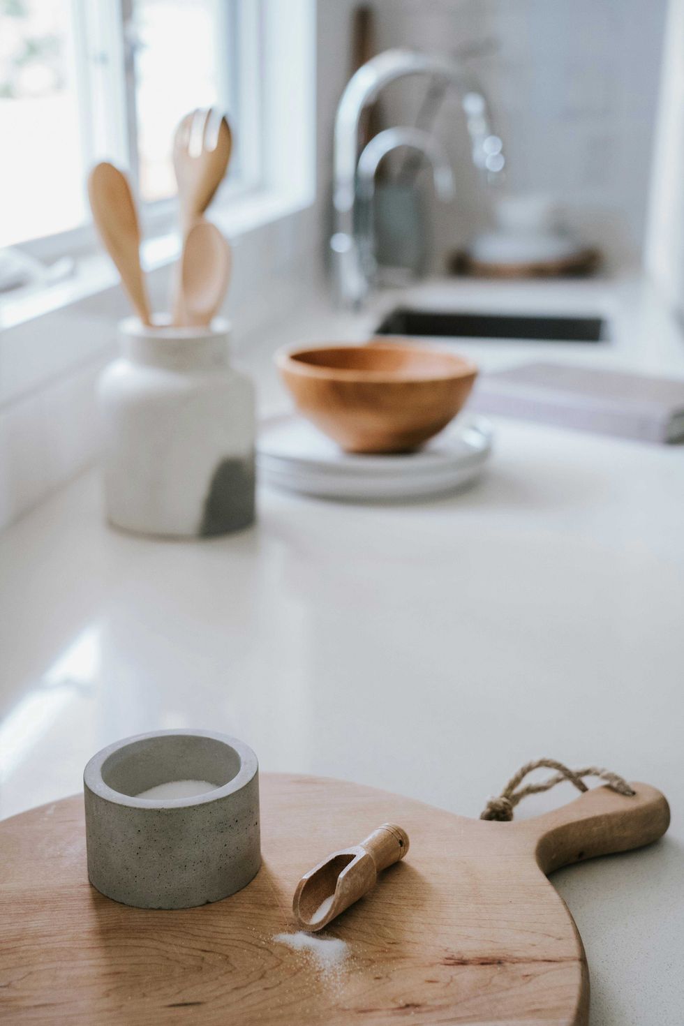 Modern kitchen counter with spice holder, wooden scoop, and utensils.