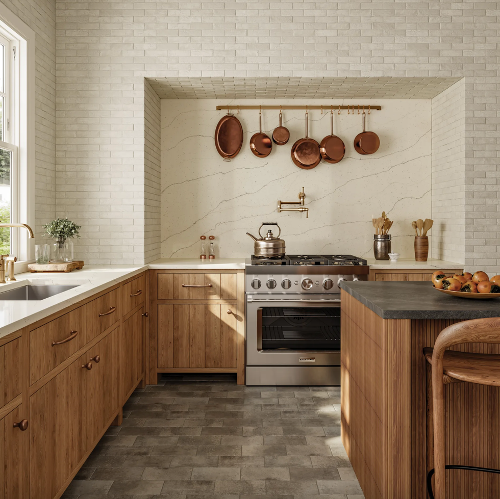 Modern kitchen with wood cabinets, copper pans, and stainless steel stove.