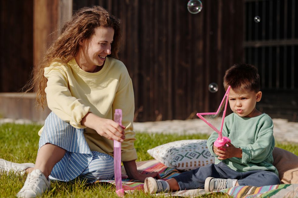 Mom and toddler playing with bubble machine