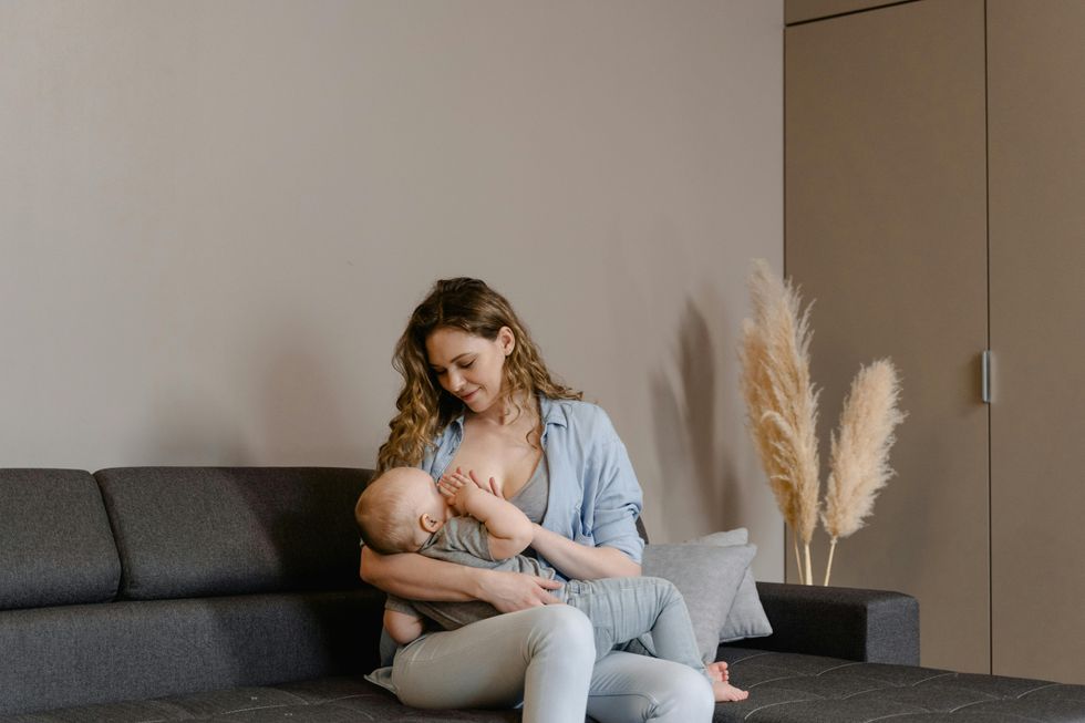 mom breastfeeding baby in living room