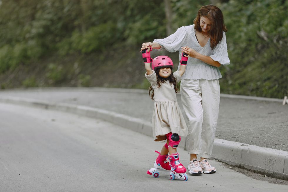 Mom teaching young daughter how to skate