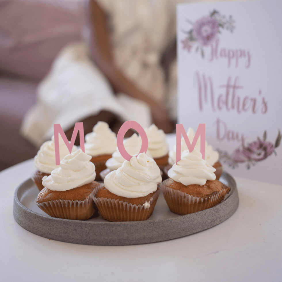 Mother's Day cupcakes on plate with "mom" letter signs