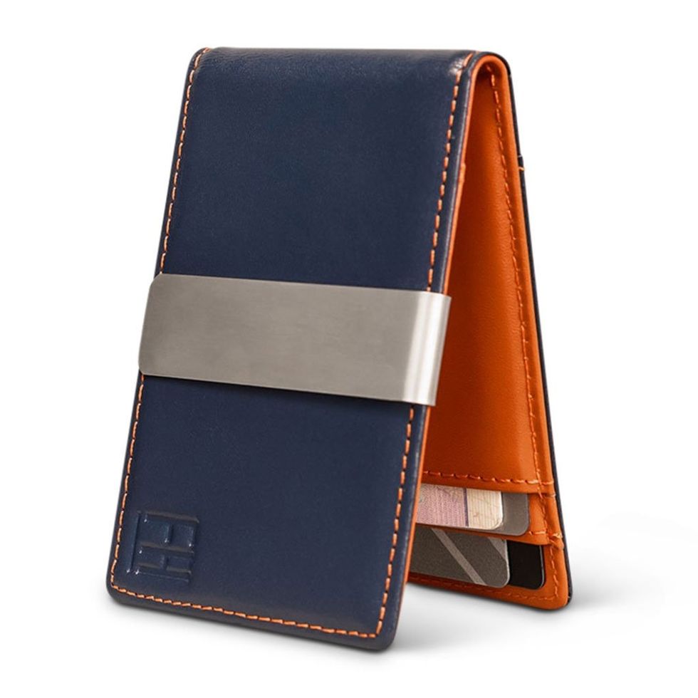Navy and orange wallet with metal clip displaying cards inside.