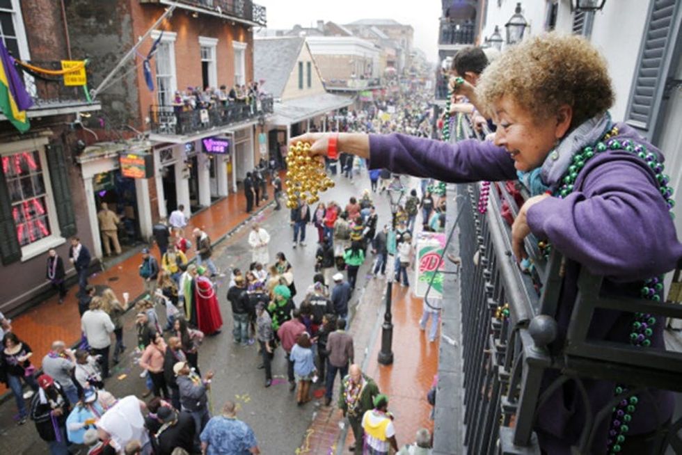 NEW OREANS, LA - FEBRUARY 12: A Mardi Gras reveler dangles a pair of beads off of a balcony on Bourbon Street in New Orleans on Mardi Gras Day. Fat Tuesday, the traditional celebration on the day before Ash Wednesday and the begining of Lent, is marked in New Orleans with parades and marches through many neighborhoods in the city. (Photo by Rusty Costanza/Getty Images)