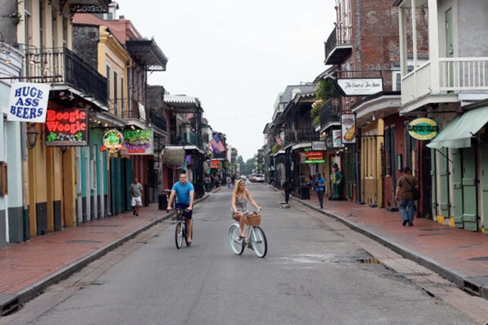 NEW ORLEANS, LA - AUGUST 27: People ride bicycles down a virtually empty Bourbon street ahead of Tropical Storm Isaac on August 27, 2012 in New Orleans, Louisiana. Tropical Storm Isaac is expected to strengthen into at least a Category 1 hurricane before making landfall near Louisiana. (Photo by Chris Graythen/Getty Images)