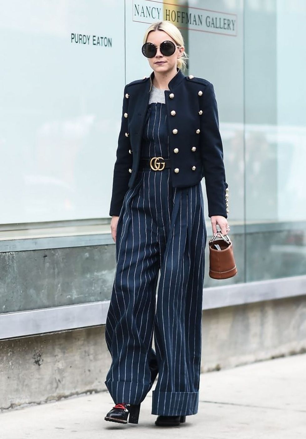 NEW YORK, NY - FEBRUARY 11: A guest is seen wearing a blue military jacket, blue striped pants suit and a Gucci belt at the Tibi show during New York Fashion Week: Women's Fall/Winter 2017 on February 11, 2017 in New York City. (Photo by Daniel Zuchnik/Getty Images)