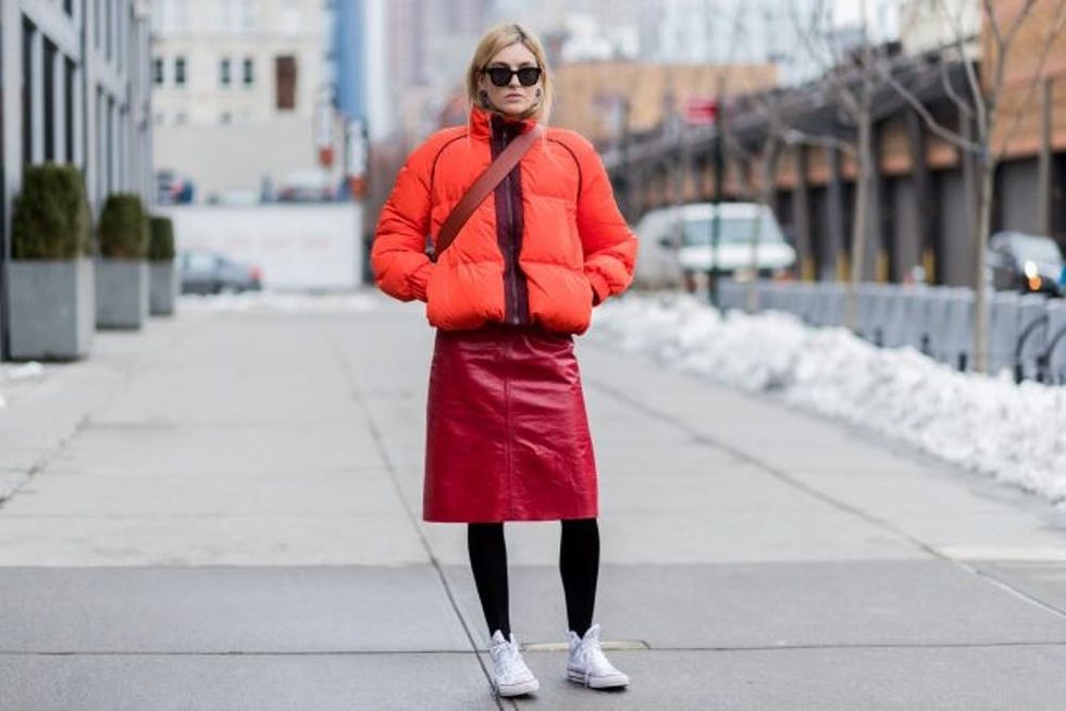 NEW YORK, NY - FEBRUARY 11: Camille Charriere wearing an orange down feather jacket, red pvc skirt, Converse sneaker outside Creatures of the Wind on February 11, 2017 in New York City. (Photo by Christian Vierig/Getty Images)