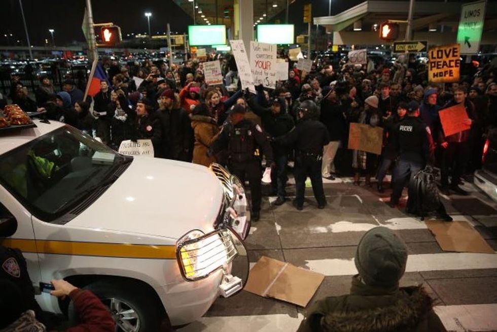 NEW YORK, UNITED STATES - JANUARY 28: Police members intervene and arrest some of activists during the protest against President Donald Trump's 90-days ban of entry on 7 Muslim-majority countries in the Fourth terminal of JFK airport in New York, U.S.A on January 28, 2017. (Photo by Mohammed Elshamy/Anadolu Agency/Getty Images)