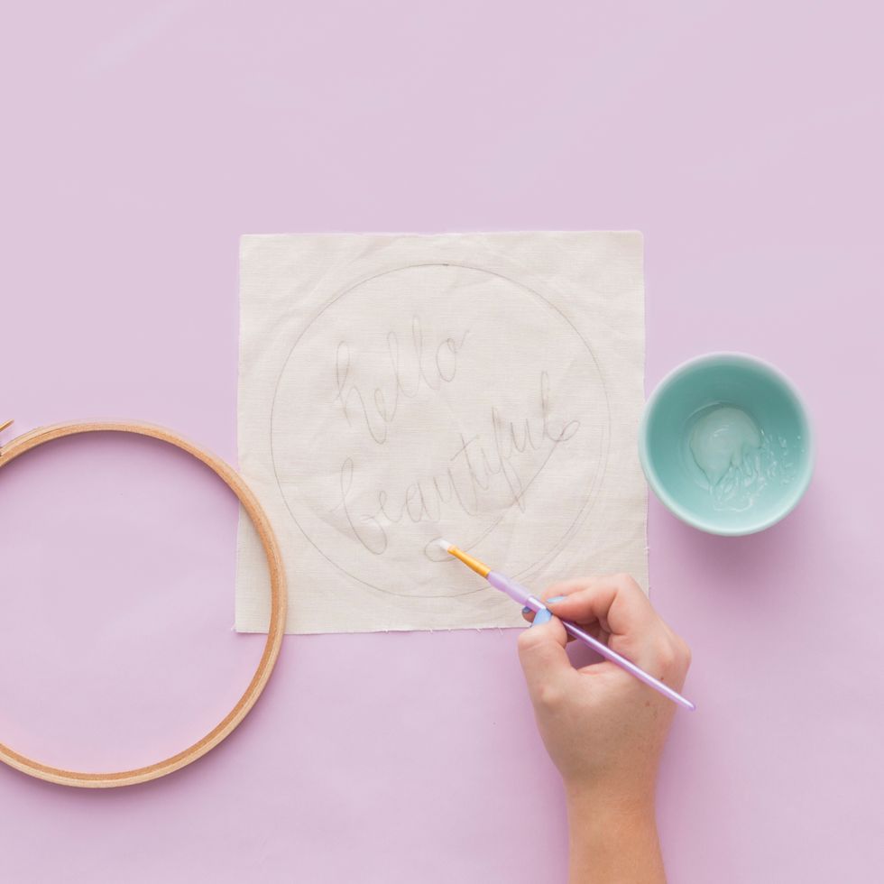 Next, paint over just your design outline (and not the circle) using a thin paintbrush and the liquid adhesive. Let it dry for 15 minutes or until tacky to the touch.