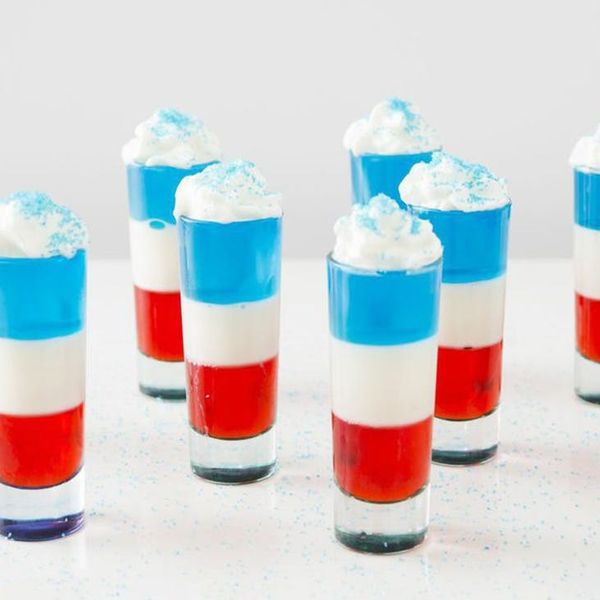 Nine red, white and blue 4th of July Jello shots topped with whipped cream and blue sprinkles