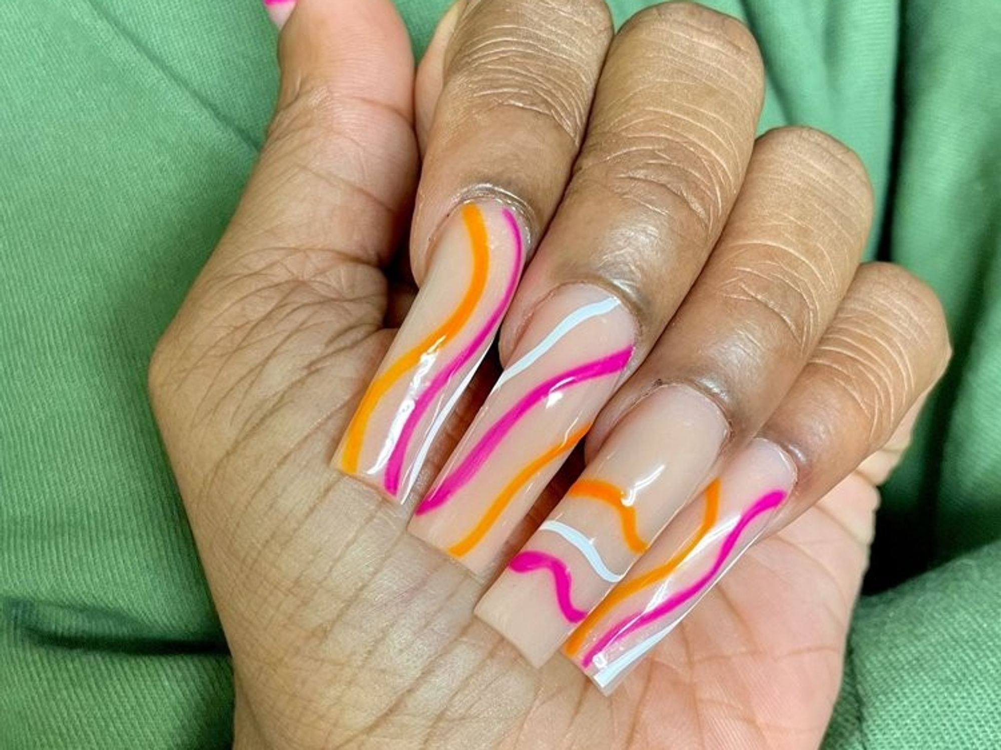 nude nails with pink, white and orange swirl designs