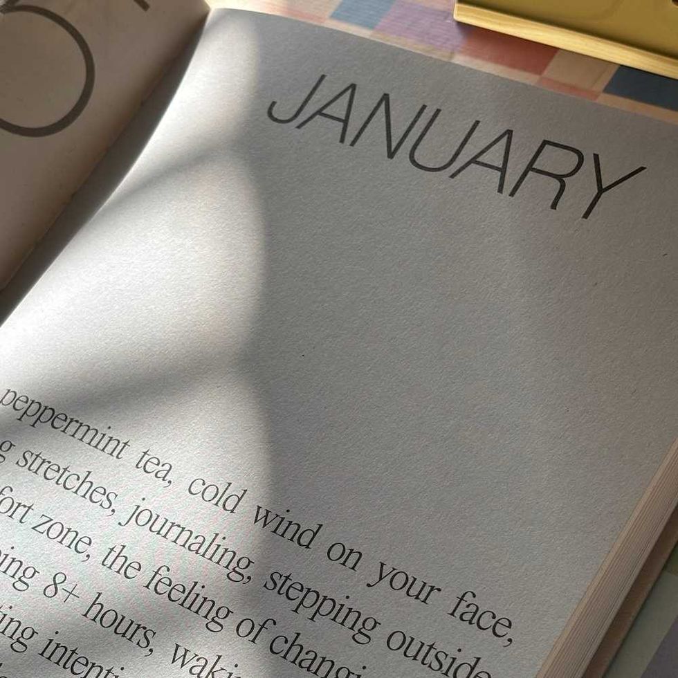 Open book with "January" and descriptive text, sunlight casting shadows on pages.