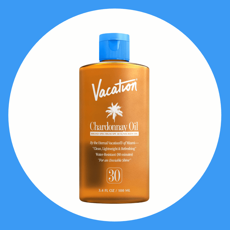 Orange bottle of Vacation Chardonnay Oil SPF 30 sunscreen with blue cap.