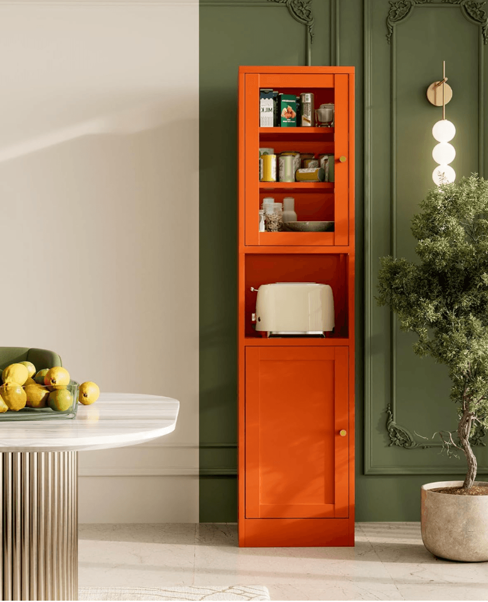 Orange cabinet, white toaster, green plant, and lemons on a table in a stylish room.