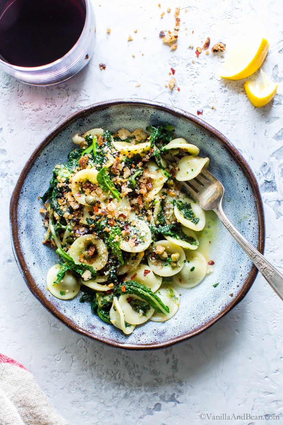 Orecchiette with garlicky kale and breadcrumbs sits in a bowl with a fork.