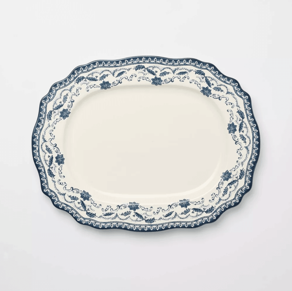 Ornate white platter with blue floral border on a plain background.