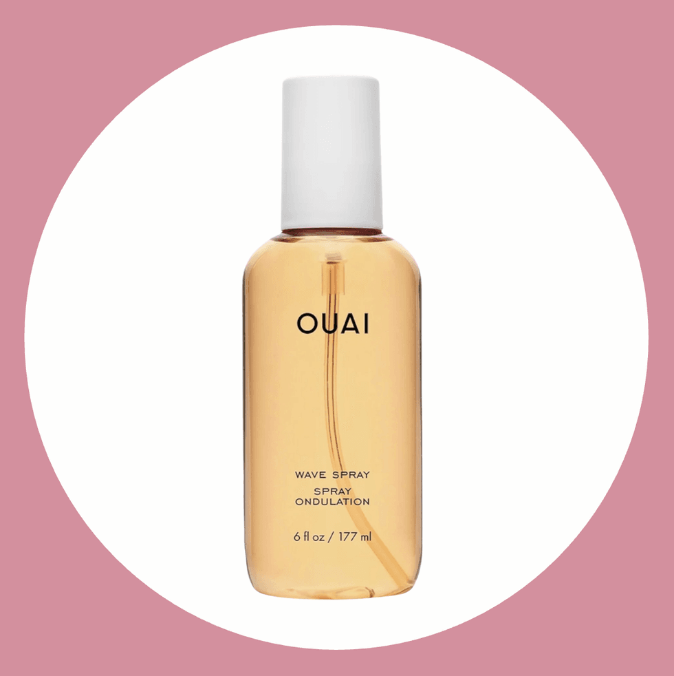 OUAI Wave Spray bottle, 6 fl oz, on a pink background.