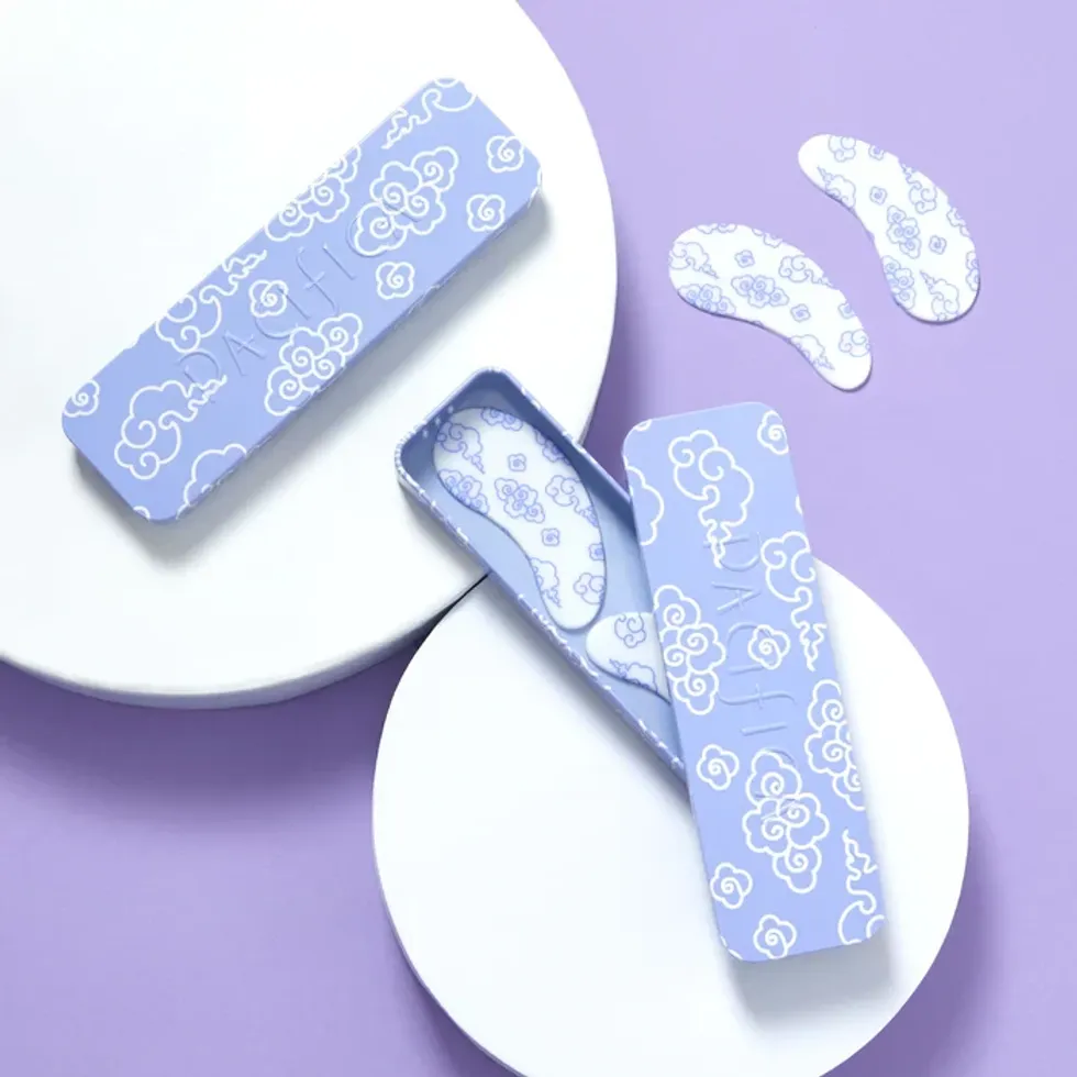 Pacifica under eye masks are in their packaging against a purple background.