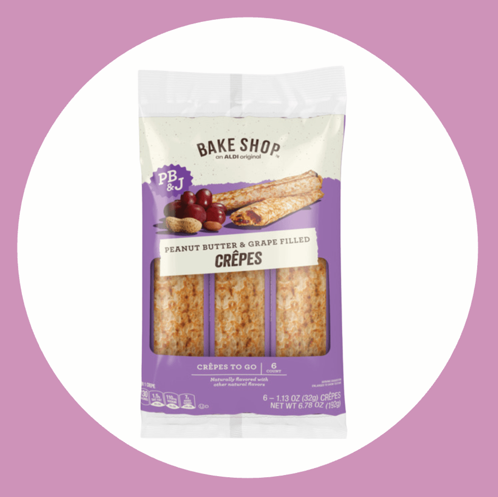 Package of peanut butter and grape-filled crepes on a purple background.