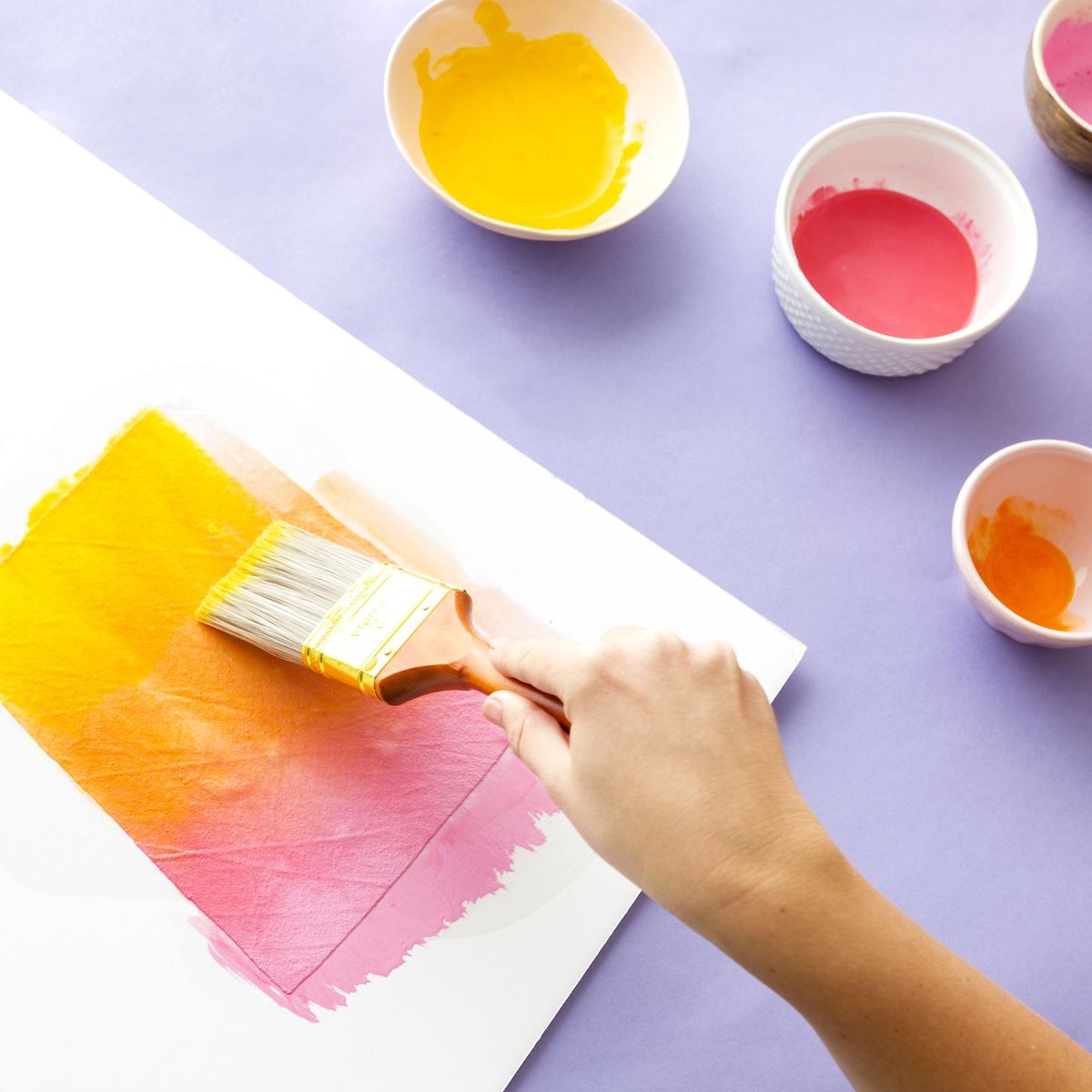 painting pink yellow and orange paint onto a white sheet tiktok home diys