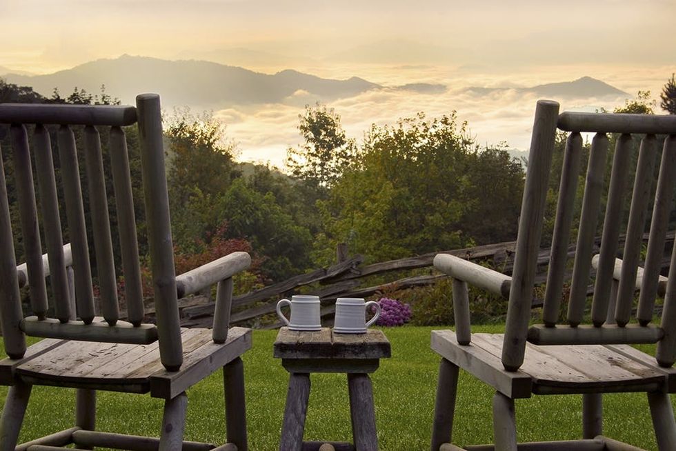 Pair of wooden chairs overlooking mountainous scenery , near Waynesville and Asheville, Smoky Mountains, USA