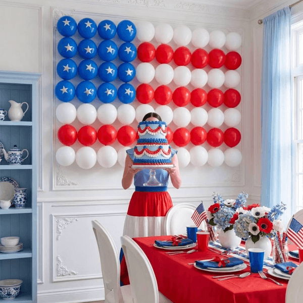 Patriotic themed party with a balloon flag and cake, red, white, and blue decorations.